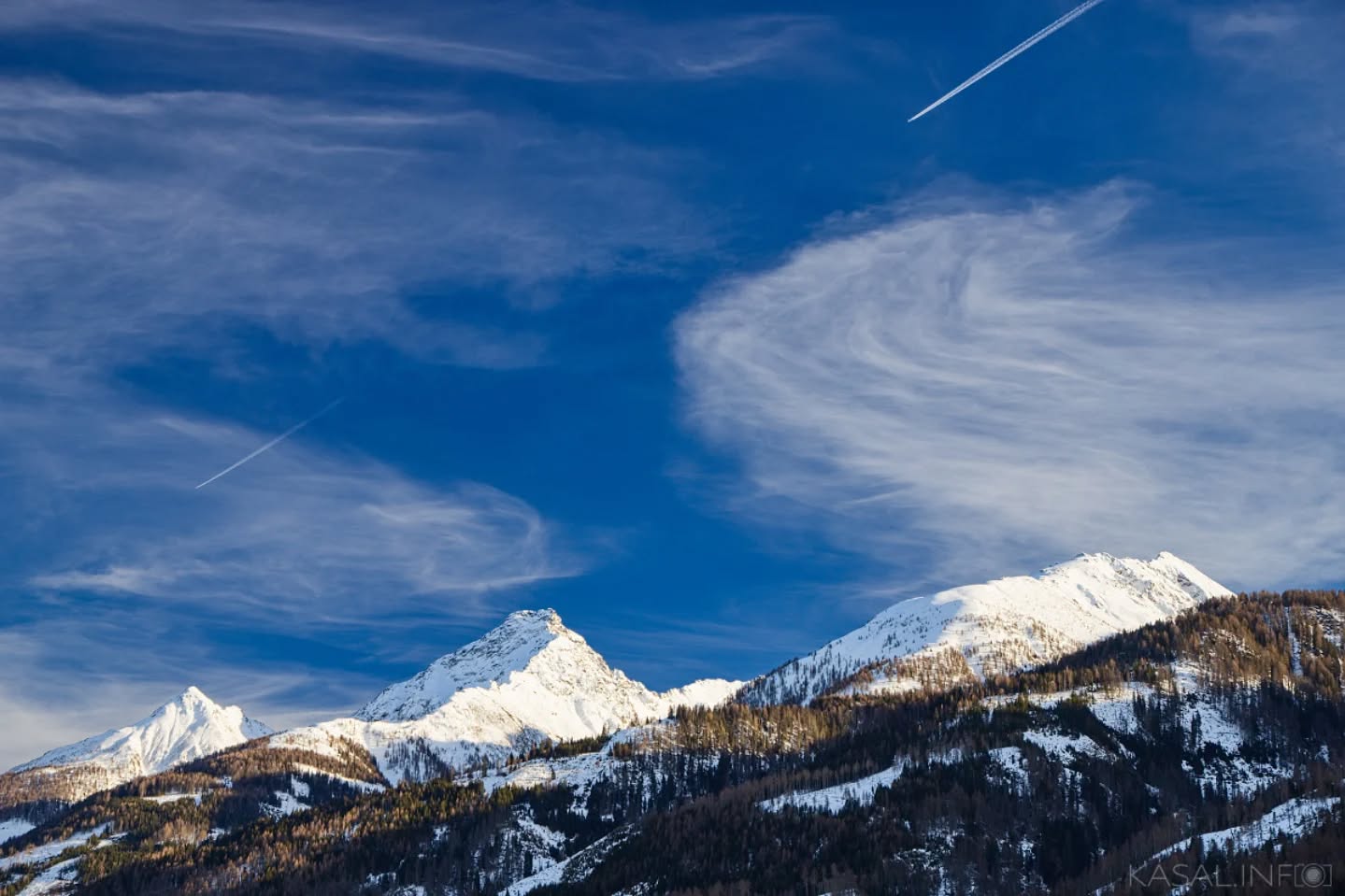 Three peaks⁠
.⁠
.⁠
Three snow-covered summits rise above the forested slopes, touched by soft winter light while high clouds drift across a deep blue sky, tracing the silent passage of time.⁠
.⁠
.⁠
#tirol #mountainlandscape #wintermountains⁠