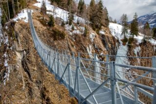 Steel Thread Over the Gorge⁠
.⁠
.⁠
A narrow steel footbridge stretches across a rugged gorge, suspended above a frozen waterfall and steep rock walls.⁠
.⁠
.⁠
#tirol #mountainlandscape #wintermountains